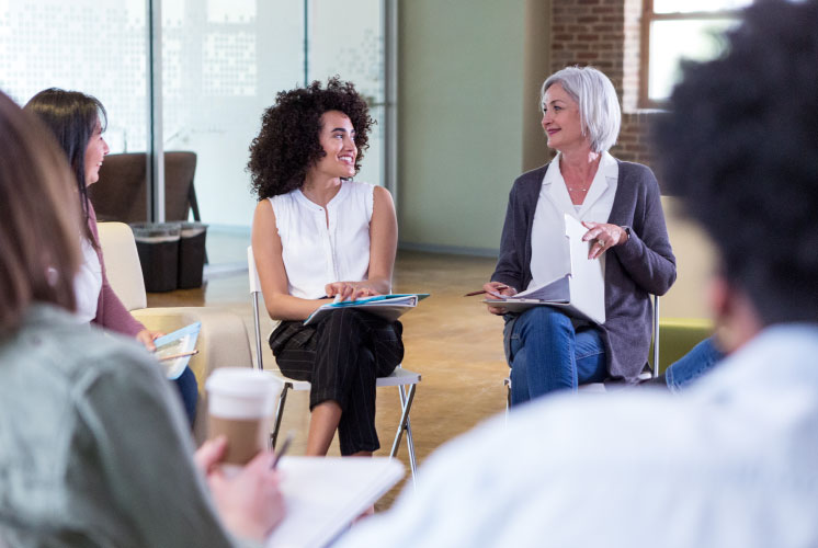 People smiling and talking in a circle