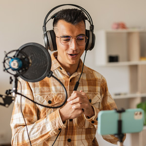 Smiling man with headphones speaking into a microphone