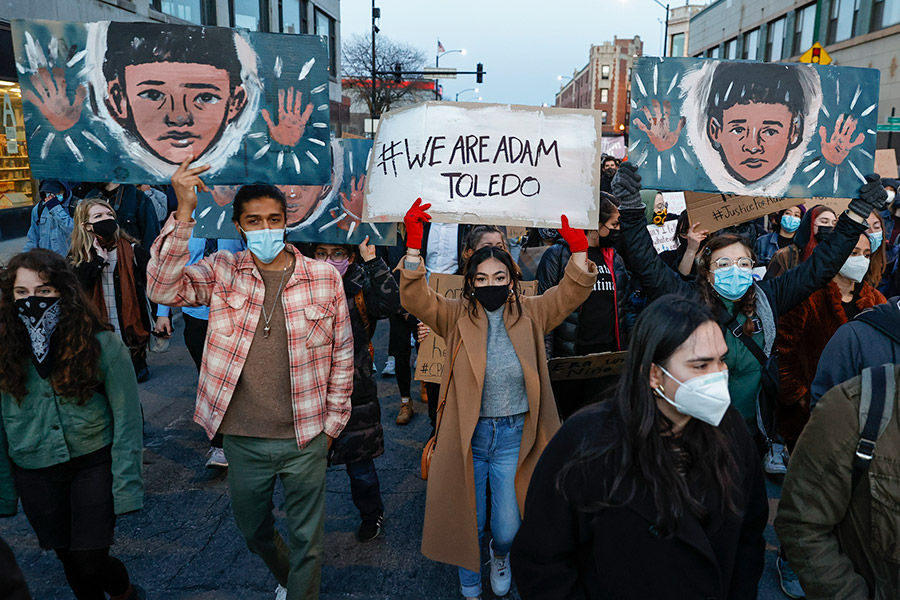 group of protestors in Chicago street with illustrations of Adam Toledo