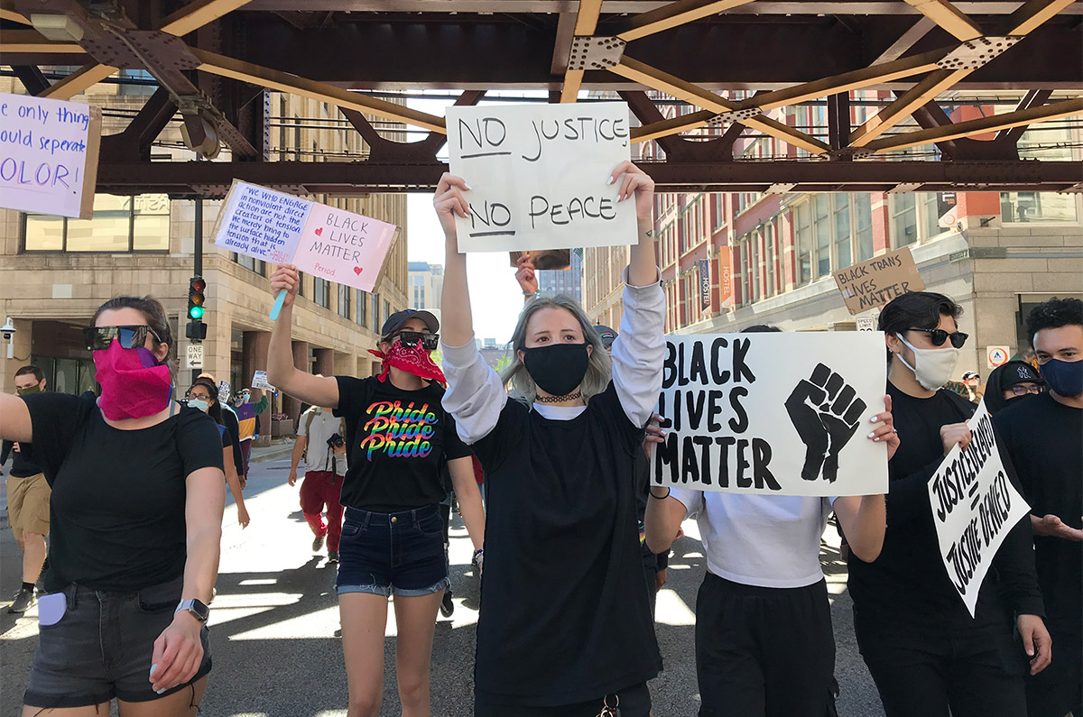 Protesters holding signs walking down Chicago street