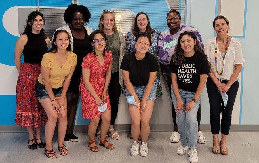 Un grupo de mujeres diversas, jóvenes y sonrientes posando para la cámara.