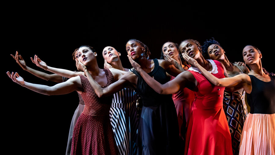 eight women dancers with their faces turned upwards