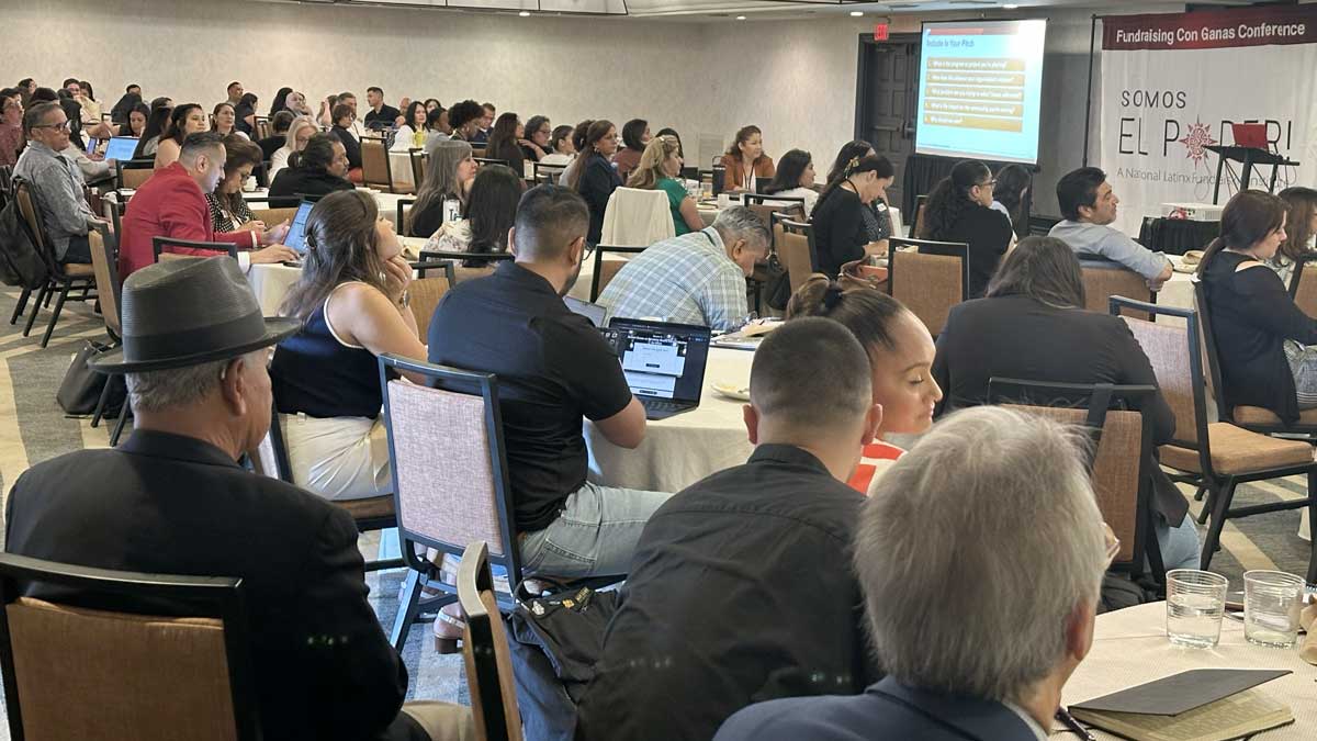 Conference attendees seated with laptops at the 