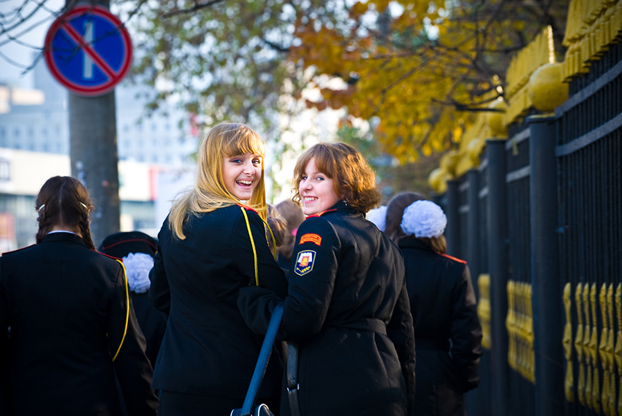 Two female military college cadets looking over their shoulders smiling