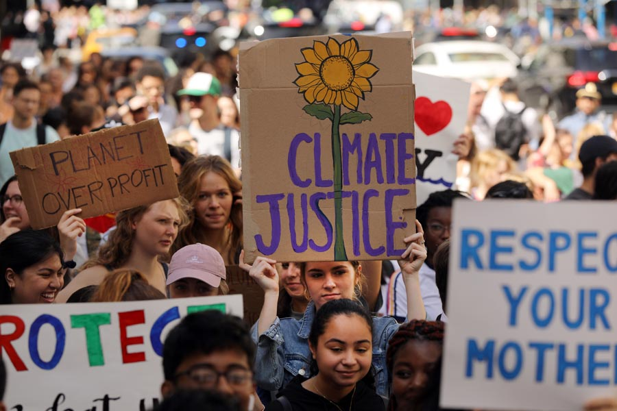 young people demonstrating climate change holding signs