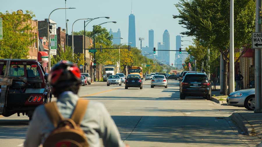 cyclist and cars on street with Chicago skyline in background