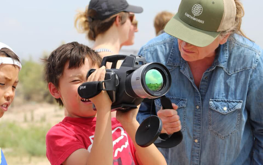 Boy_Holding_And_Looking_Through_Infrared_Camera_With_Adult_Assisting