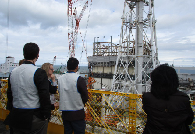 Group_Of_People_Looking_At_Damaged_Nuclear_Reactor_In_Fukushima_Daiichi