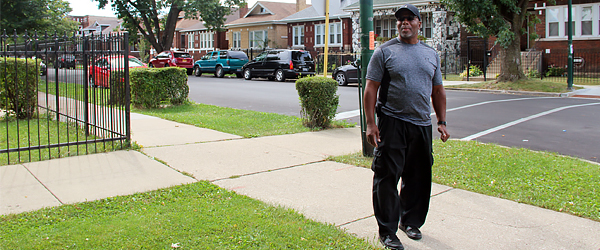 AfricanAmericanmanwalkingalongneighborhoodsidewalk