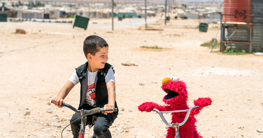Boy_On_Bicycle_Next_To_Red_Muppet_On_Bicycle