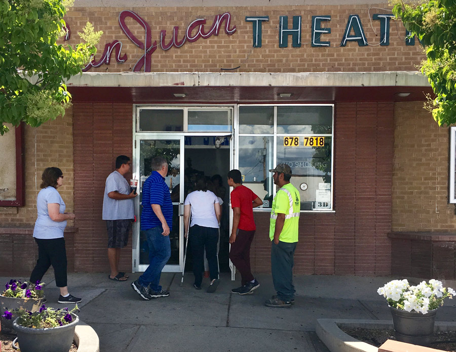 Latinx_And_White_People_Entering_Doors_Of_Small_Brick_Building